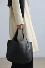 Profile view of model wearing the Oroton Emilia Large Tote in Black and Premium pebble leather for Women .