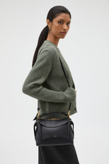 Profile view of model wearing the Oroton Mica Bowler in Black and Premium pebble grain leather for Women .