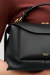 Profile view of model wearing the Oroton Mica Bowler in Black and Premium pebble grain leather for Women .