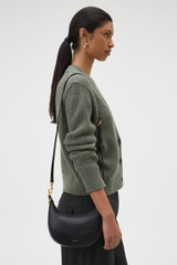Profile view of model wearing the Oroton Florence Small Shoulder Bag in Black and Premium smooth leather for Women .