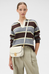 Profile view of model wearing the Oroton Yvonne Small Saddle Bag in Cream and Pebble Leather for Women .