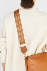 Profile view of model wearing the Oroton Heather Long Light Gold Webbing Strap in Tan/Cognac and 100% polyester material for Women .