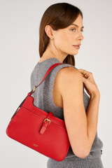 Profile view of model wearing the Oroton Dylan Baguette in Dark Ruby and Premium pebble leather for Women .