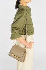 Profile view of model wearing the Oroton Elm Small Satchel in Mushroom and Smooth Pebble Leather for Women .