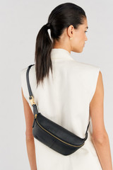 Profile view of model wearing the Oroton Lilly Belt Bag in Black and Premium smooth leather for Women .