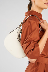 Profile view of model wearing the Oroton Dylan Mini Hobo in Cream and Premium pebble leather for Women .
