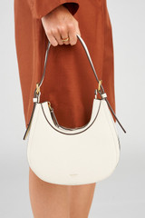 Profile view of model wearing the Oroton Dylan Mini Hobo in Cream and Premium pebble leather for Women .