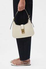 Profile view of model wearing the Oroton Yvonne Baguette in Cream and Premium pebble leather for Women .