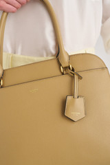 Profile view of model wearing the Oroton Iris Double Zip 14" Tote Bag in Mushroom and Premium pebble leather for Women .