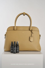 Profile view of model wearing the Oroton Iris Double Zip 14" Tote Bag in Mushroom and Premium pebble leather for Women .