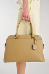 Profile view of model wearing the Oroton Iris Double Zip 14" Tote Bag in Mushroom and Premium pebble leather for Women .