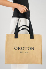 Profile view of model wearing the Oroton Everyday Tote in Straw and Crafted from 99.9% recycled polyester material for Women .