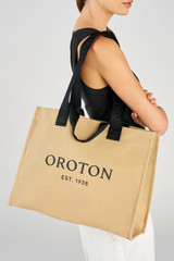 Profile view of model wearing the Oroton Everyday Tote in Straw and Crafted from 99.9% recycled polyester material for Women .