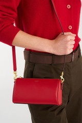 Profile view of model wearing the Oroton Harvey Baguette Crossbody in DARK RUBY and Premium smooth leather for Women . IP:2