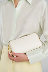 Profile view of model wearing the Oroton Harvey Baguette Crossbody in Cream and Premium smooth leather for Women .