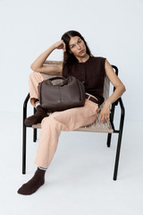 Profile view of model wearing the Oroton Dorit Hobo Bag in COFFEE BEAN and Premium pebble leather for Women .