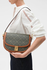 Profile view of model wearing the Oroton Yvonne Signature Medium Saddle Bag in Cognac and Nylon canvas base cloth material with PVC coating (70% PVC, 30% polyester) for Women .