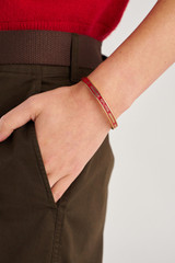 Profile view of model wearing the Oroton Heather Enamel Bangle in Gold/Dark Ruby and Premium brass material for Women .