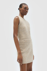 Profile view of model wearing the Oroton Nep Knit Mini Skirt in Oat and 65% merino wool, 30% nylon, and 5% alpaca blend fabric for Women .
