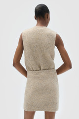 Profile view of model wearing the Oroton Nep Knit Mini Skirt in Oat and 65% merino wool, 30% nylon, and 5% alpaca blend fabric for Women .
