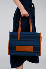 Profile view of model wearing the Oroton Sasha Medium Tote in PRUSSIAN BLUE MIX and 100% polyester fabric for Women .