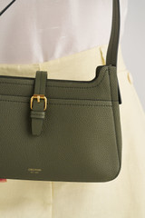 Profile view of model wearing the Oroton Dylan Baguette in CACTUS and Premium embossed leather for Women .