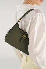 Profile view of model wearing the Oroton Dylan Baguette in CACTUS and Premium embossed leather for Women .