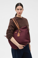 Profile view of model wearing the Oroton Lilly Nylon Light Weight Tote Bag in BURGUNDY and Nylon fabric for Women .