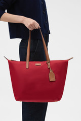 Profile view of model wearing the Oroton Lilly Nylon Light Weight Tote Bag in DARK RUBY and Nylon fabric for Women .