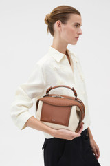 Profile view of model wearing the Oroton Mica Canvas Broguing Bowler in NATURAL/PENNY BROWN and Premium canvas material for Women .