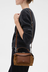 Profile view of model wearing the Oroton Mica Mini Suede Bowler in Teak and Premium suede leather for Women .