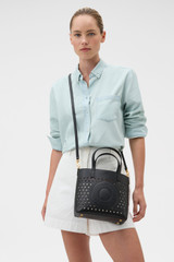Profile view of model wearing the Oroton Polly Perforated Small Tote in Black and Premium smooth leather for Women .