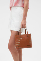 Profile view of model wearing the Oroton Polly Perforated Small Tote in Cognac and Premium smooth leather for Women .