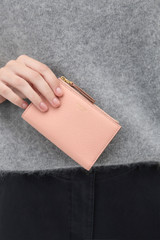 Profile view of model wearing the Oroton Eve 12 Credit Card Zip Wallet in BLOSSOM and Premium pebble leather for Women .