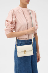 Profile view of model wearing the Oroton Yvonne Wallet Clutch in CREAM and Premium pebble leather for Women .