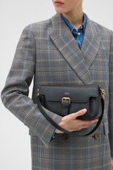 Profile view of model wearing the Oroton Dylan Day Bag in BLACK and Premium pebble leather for Women .