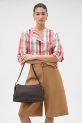 Profile view of model wearing the Oroton Cali Shoulder Bag in DARK CHOCOLATE and Premium smooth leather for Women .