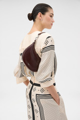 Profile view of model wearing the Oroton Florence Small Shoulder Bag in COPPER and Premium crackle leather for Women .