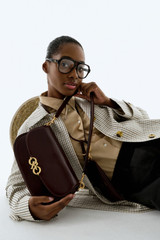 Profile view of model wearing the Oroton Olivia Day Bag in COPPER and Premium crackle leather for Women .