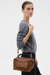 Profile view of model wearing the Oroton Mica Suede Bowler in Teak and Premium suede leather for Women .