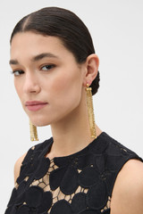Profile view of model wearing the Oroton Mara Long Tassel Earrings in Worn Gold and Premium brass material for Women .