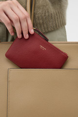 Profile view of model wearing the Oroton Eve Small Pouch in BERRY and Premium pebble leather for Women .