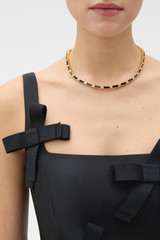 Profile view of model wearing the Oroton Eden Necklace in Black/Worn Gold and Premium brass material for Women .