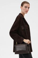 Profile view of model wearing the Oroton MICA WORKMANSHIP BOWLER in Dark Chocolate and Premium smooth leather with a refined finish for Women .