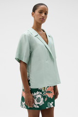 Profile view of model wearing the Oroton Short Sleeve Wrap Shirt in Glass and 100% silk dupion fabric for Women .