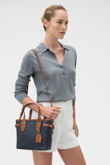 Profile view of model wearing the Oroton Laura Small Tote in Dark Navy/Cognac and Premium pebble leather for Women .