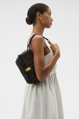 Profile view of model wearing the Oroton Etta Texture Medium Clutch in Dark Chocolate and Woven straw material for Women .