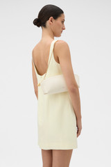 Profile view of model wearing the Oroton Naia Texture Clutch in Clotted Cream and Textured leather outer for Women .