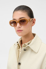 Profile view of model wearing the Oroton Soren Sunglasses in Clay and Made from Acetate material for Women .