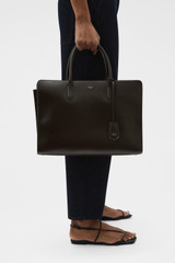 Profile view of model wearing the Oroton Muse 15" Worker Tote in Dark Chocolate and Saffiano leather exterior for Women .